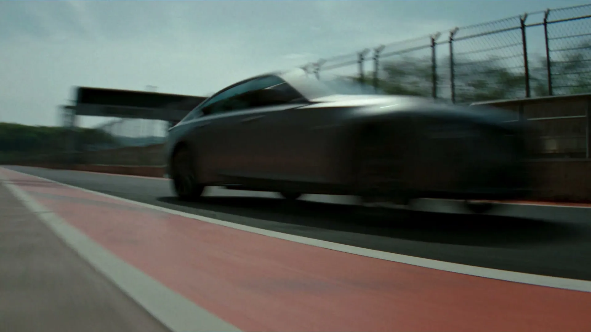 A CT5 at speed past the pit lane