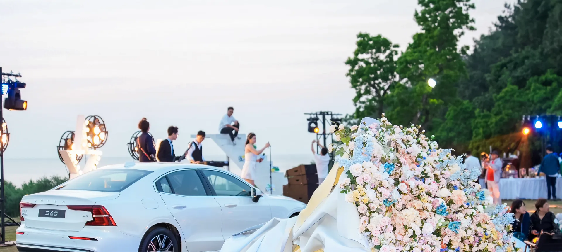 A Volvo S60 at the 520 camping event, with a band on stage behind